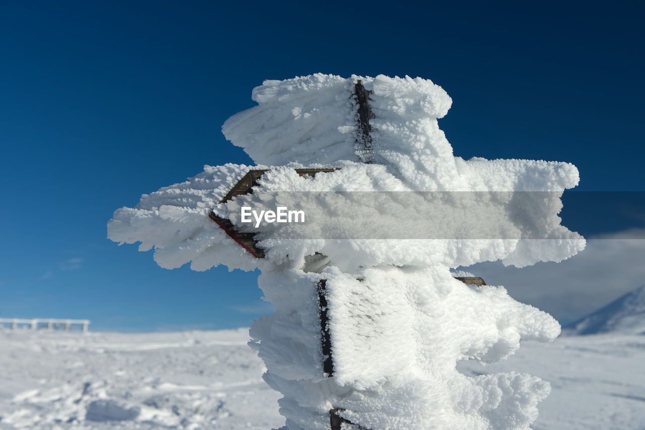 CLOSE-UP OF SNOW AGAINST CLEAR SKY