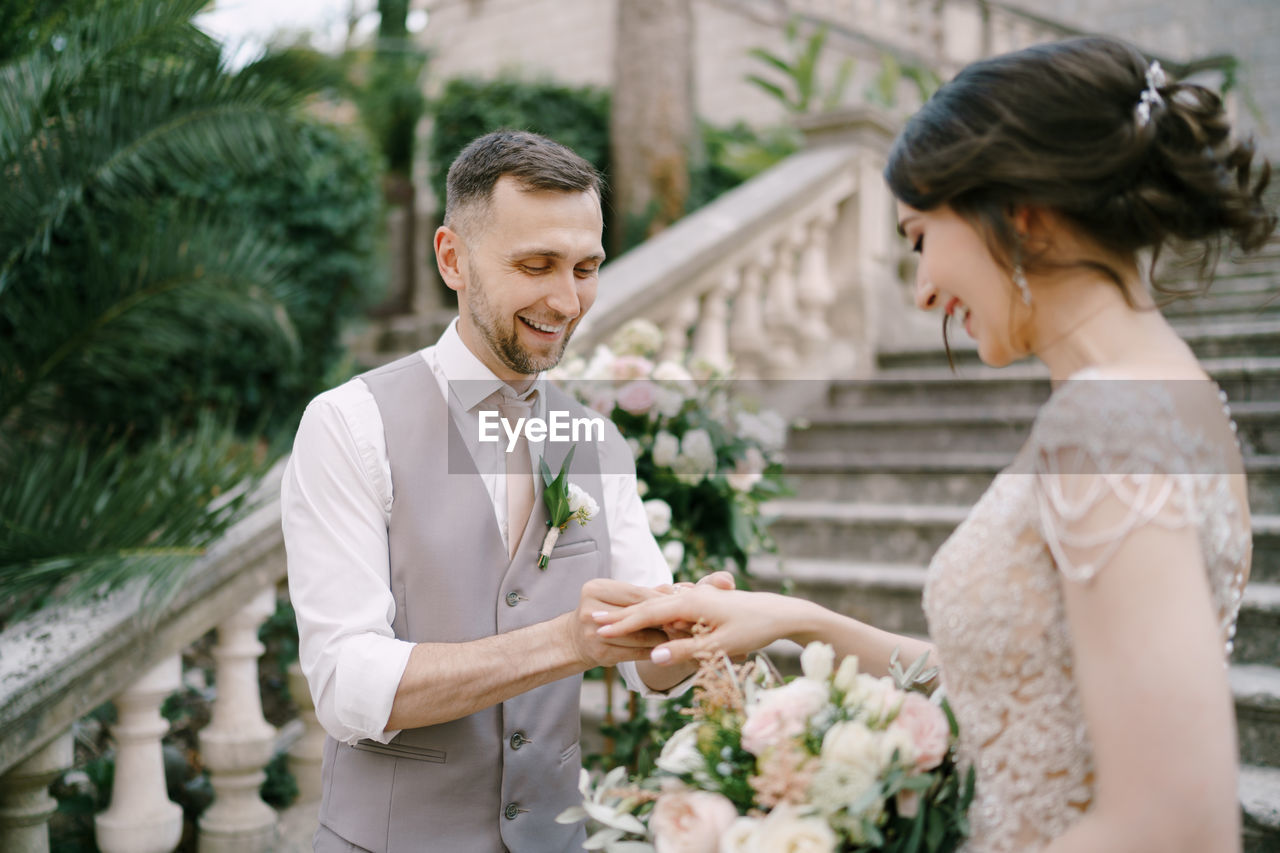 Portrait of bride and bridegroom holding bouquet