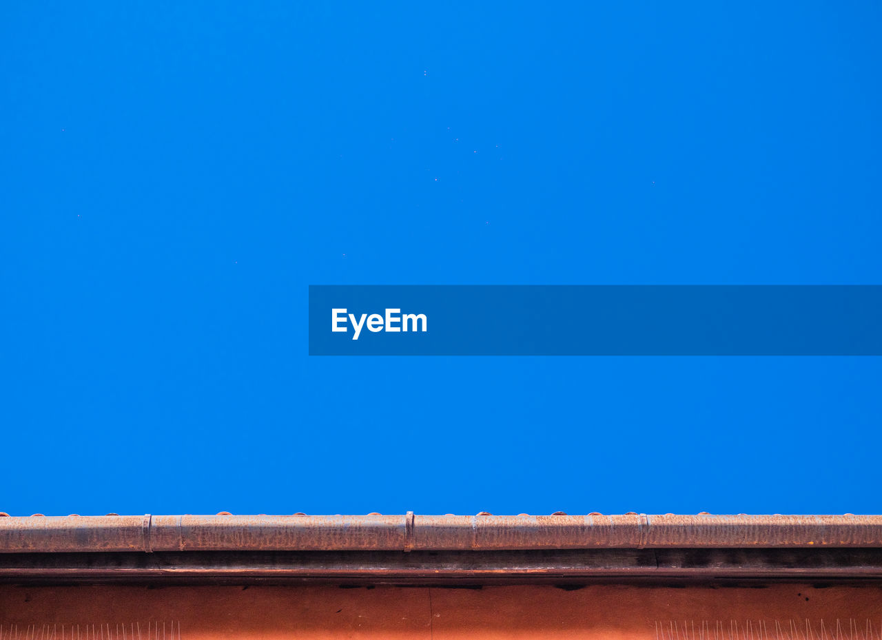 LOW ANGLE VIEW OF ROOF AGAINST BLUE SKY