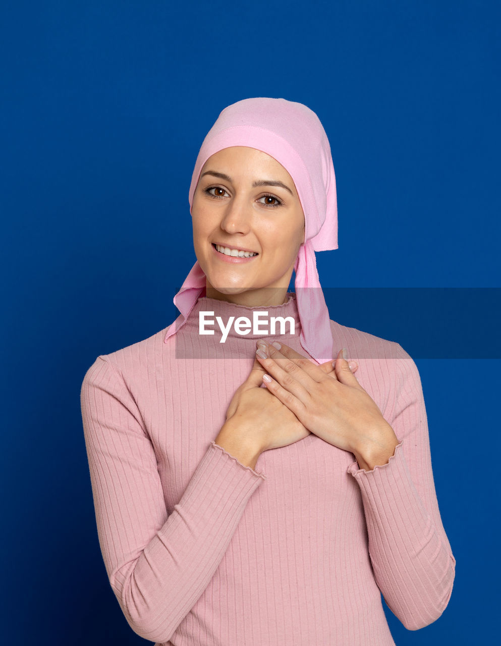 Portrait of beautiful young woman against blue background