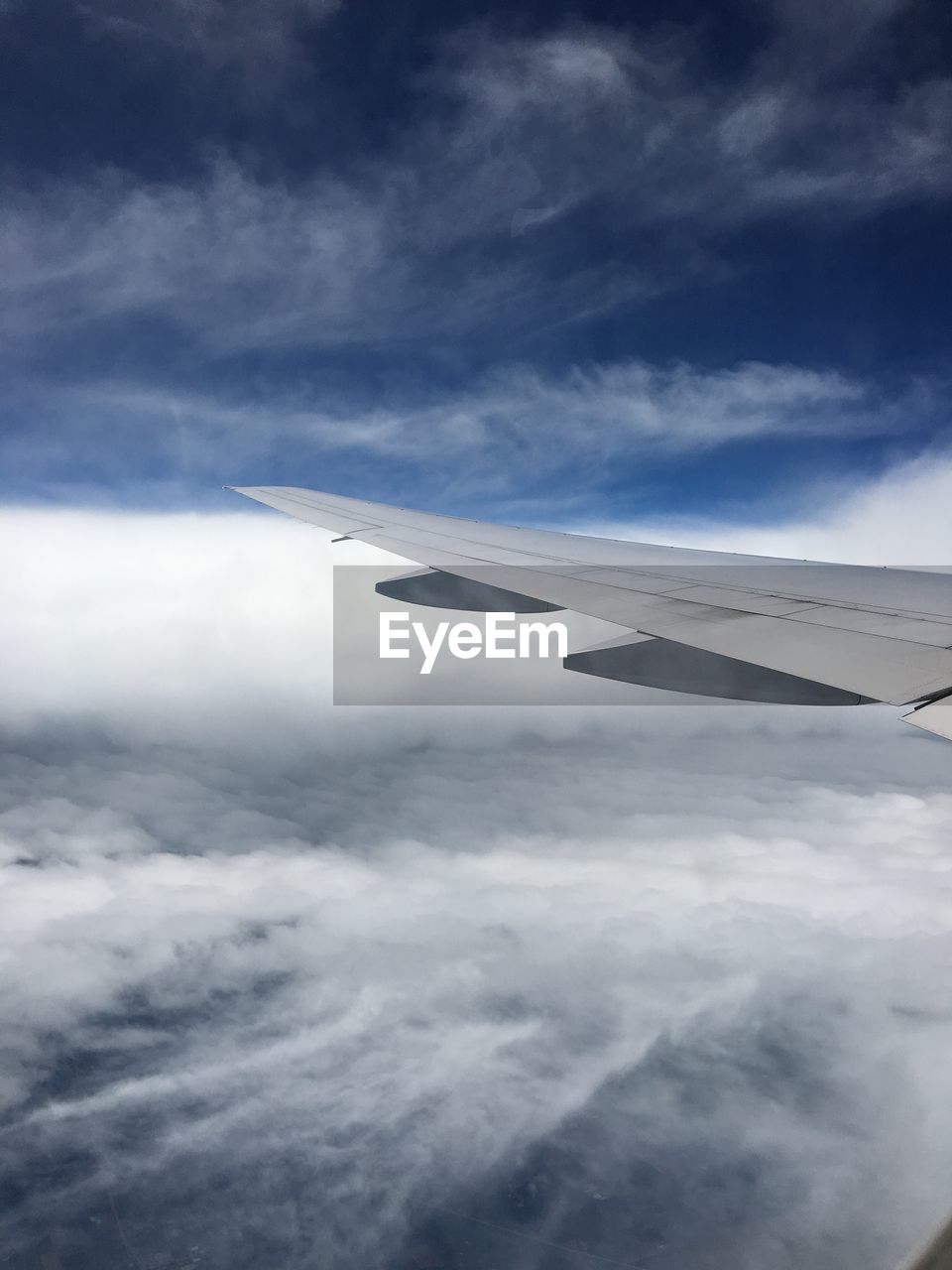 AERIAL VIEW OF AIRPLANE WING OVER CLOUDS