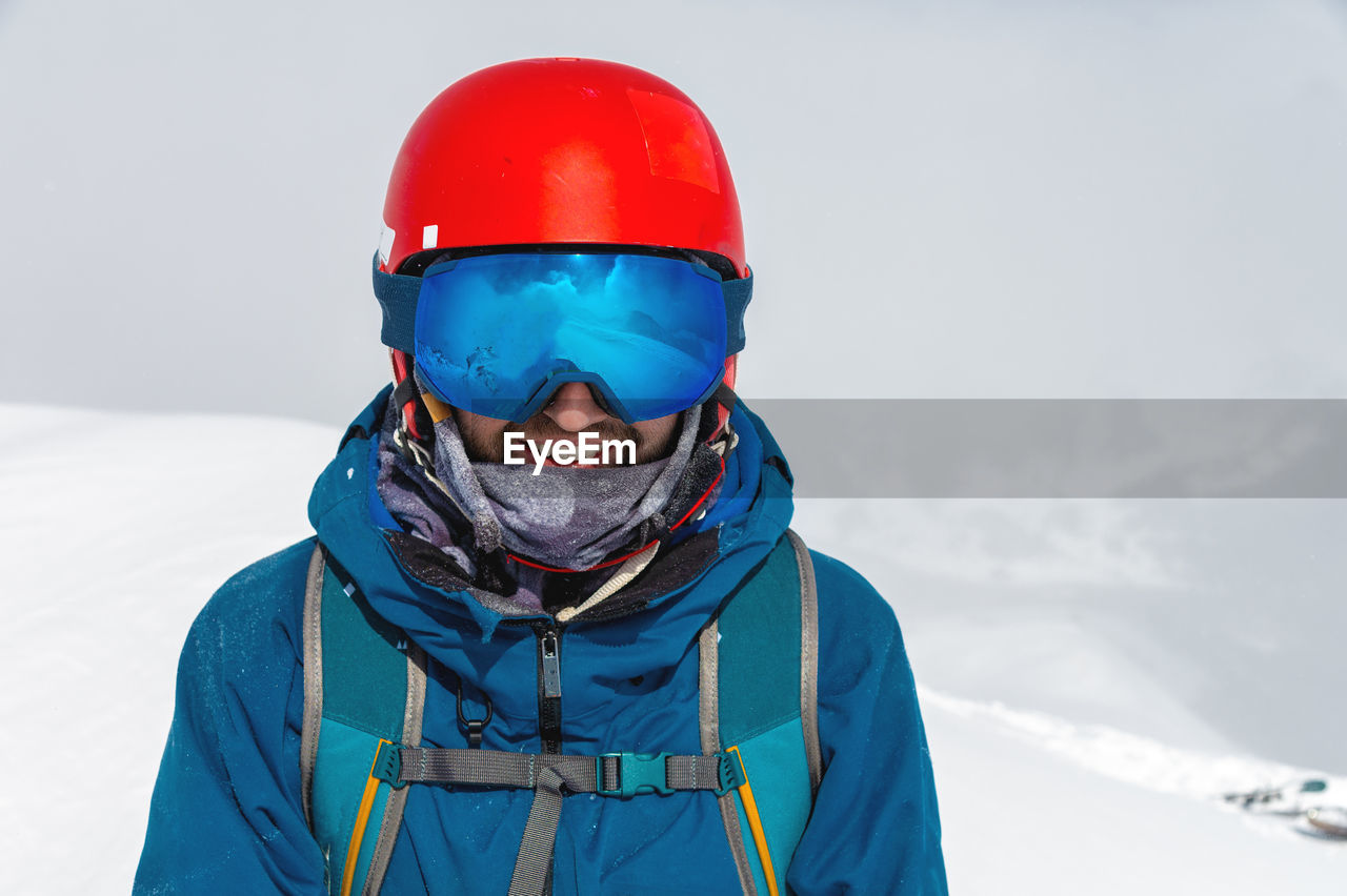 Cheerful skier looking at camera before starting to skiing. happy man enjoying holiday in winter