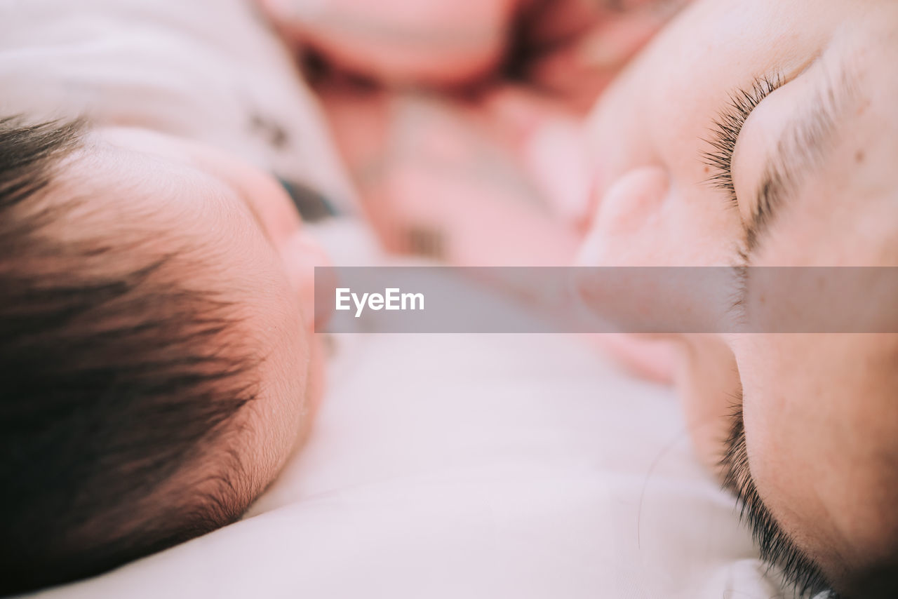 Close-up of mother and son on bed