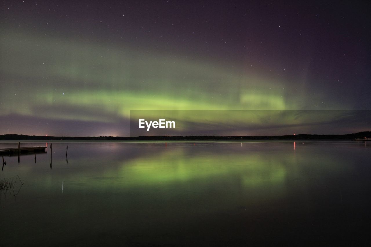 Scenic view of lake against aurora borealis at night