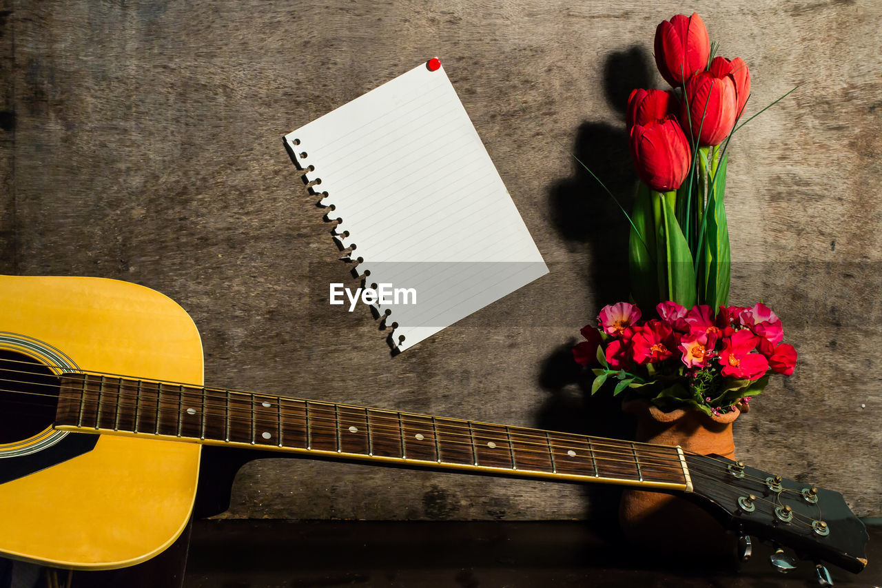 Still life photography with paper notes and guitar.