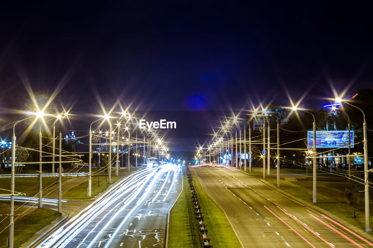 TRAFFIC LIGHT TRAILS ON ROAD AT NIGHT