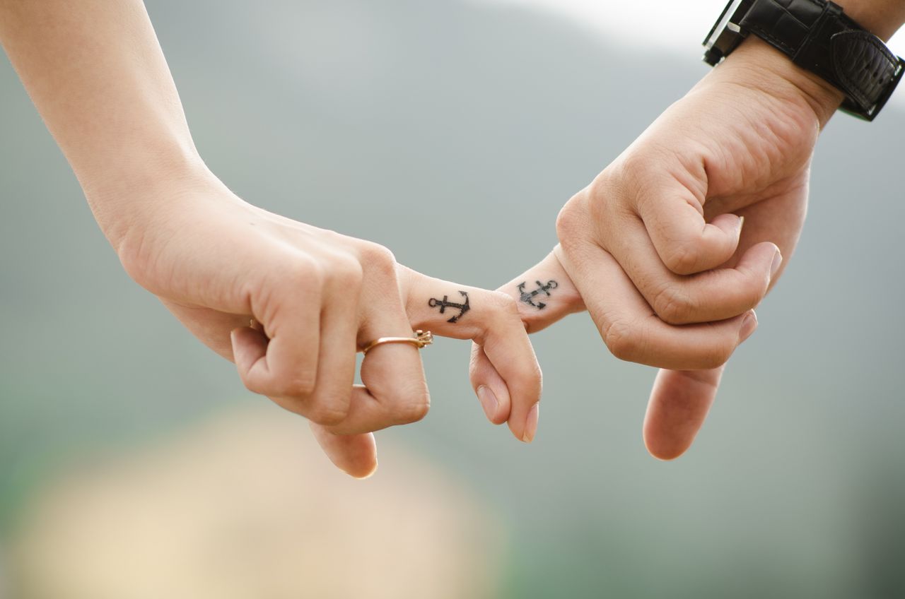 CLOSE-UP OF HAND HOLDING HANDS WITH BLURRED BACKGROUND