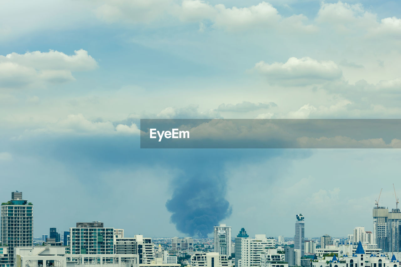 Huge explosion and fire at plastic factory on outskirts of town, thick black smoke filled sky