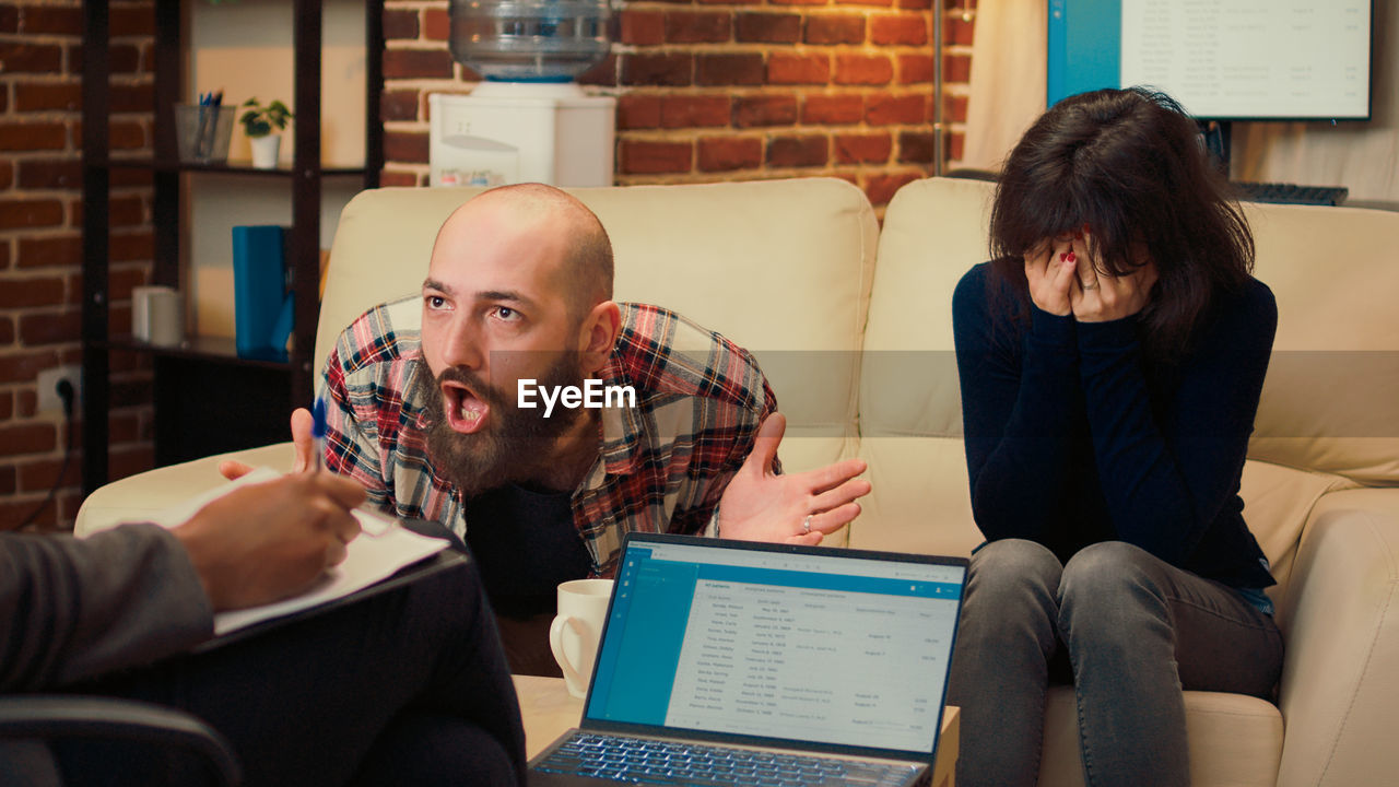 young woman using laptop while sitting at office