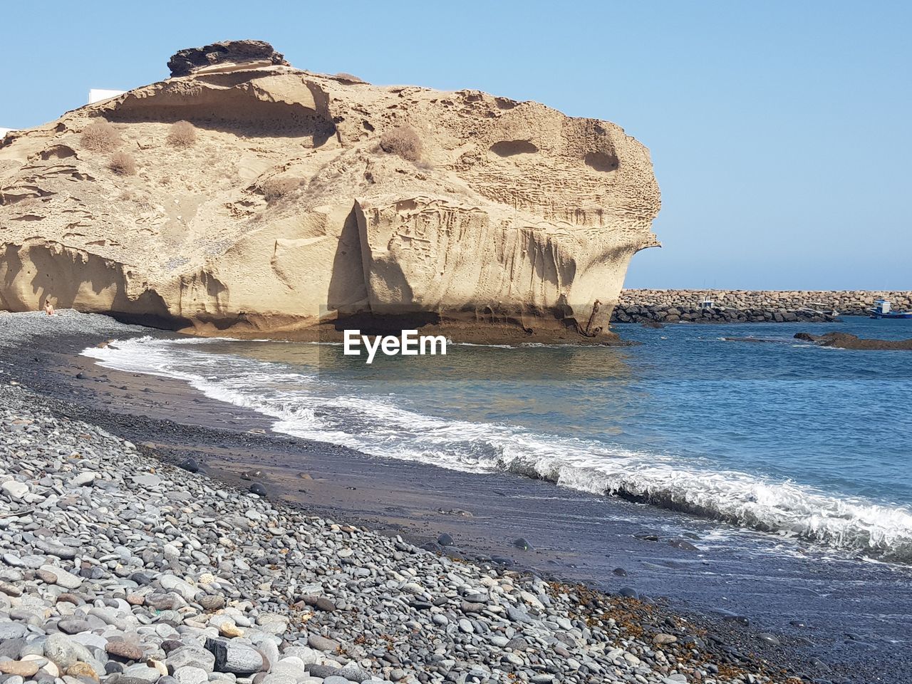 VIEW OF ROCK FORMATION ON BEACH AGAINST CLEAR SKY