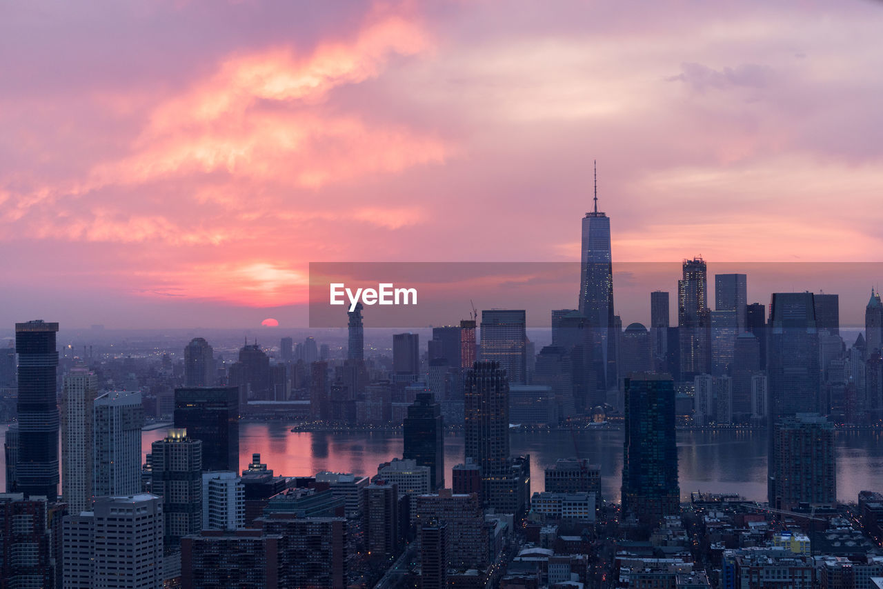 View of cityscape against cloudy sky during sunset