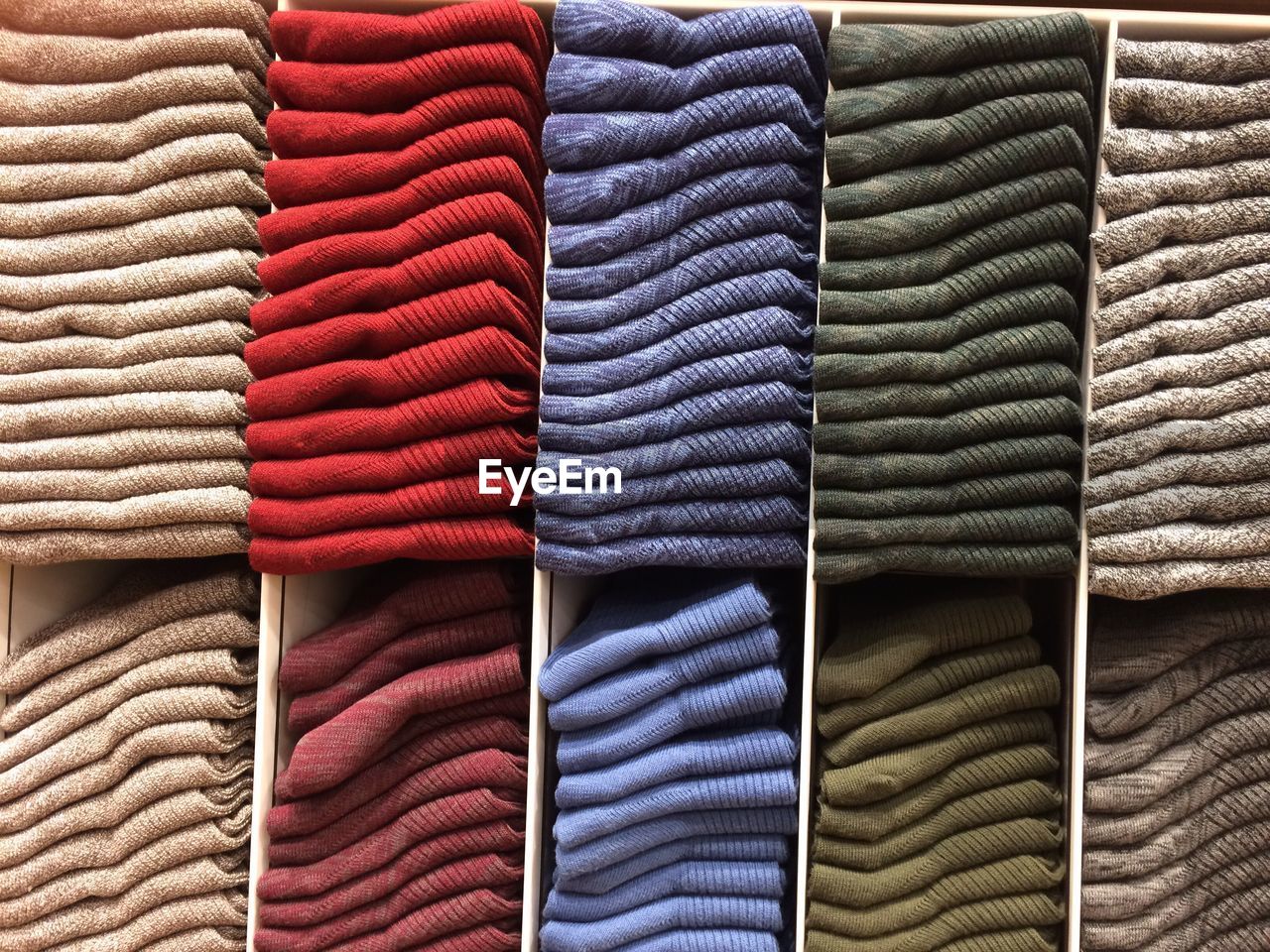 Full frame shot of multi colored sweaters stacked in store