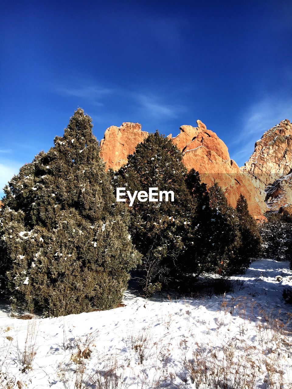 SNOW COVERED ROCKS ON MOUNTAIN AGAINST SKY