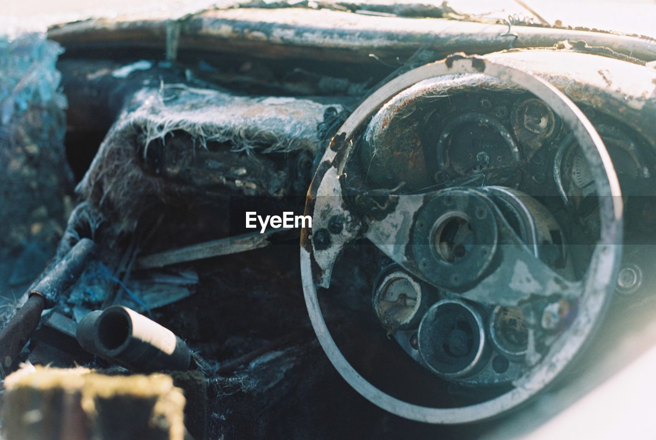 CLOSE-UP OF RUSTY WHEEL IN ABANDONED CONTAINER