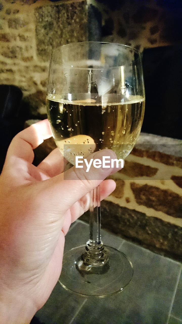 CLOSE-UP OF HAND HOLDING GLASS OF WINE