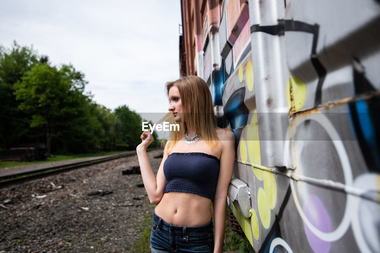 WOMAN STANDING BY RAILROAD TRACKS