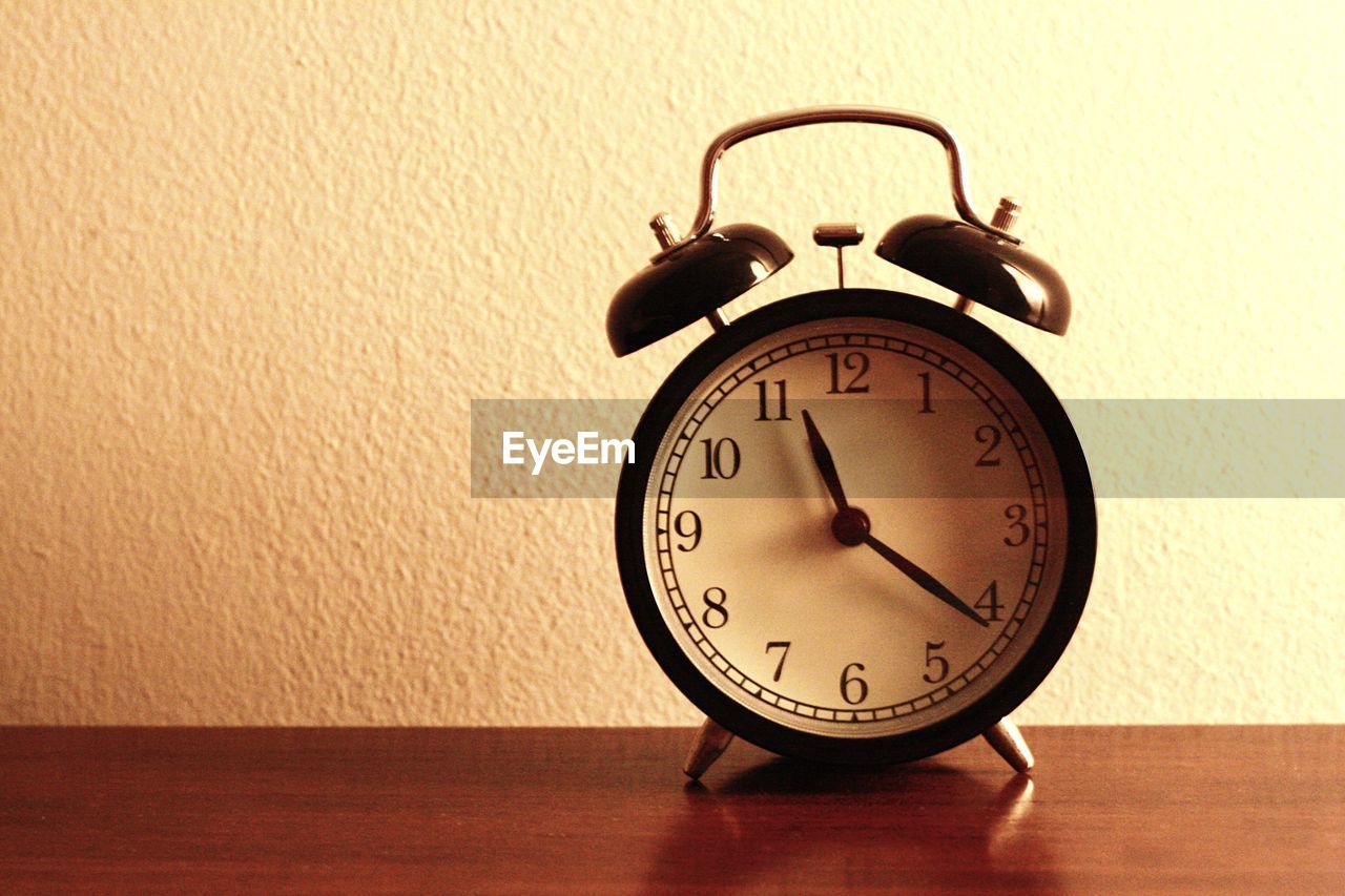 Alarm clock on wooden table at home