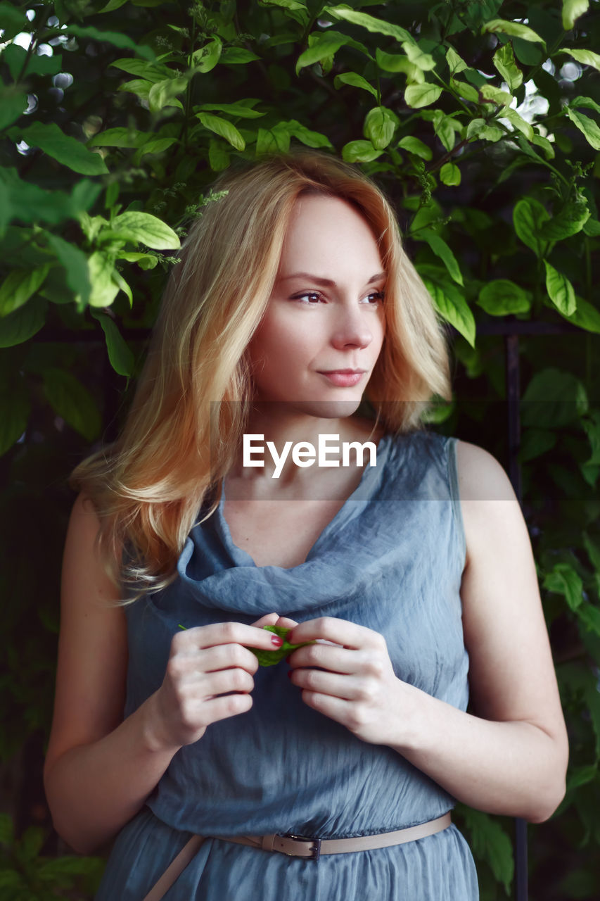 Beautiful woman standing against plants