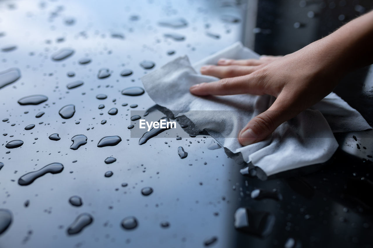 CLOSE-UP OF PERSON HAND HOLDING WET GLASS