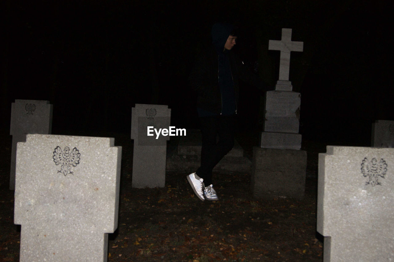 Full length of man standing at cemetery during night