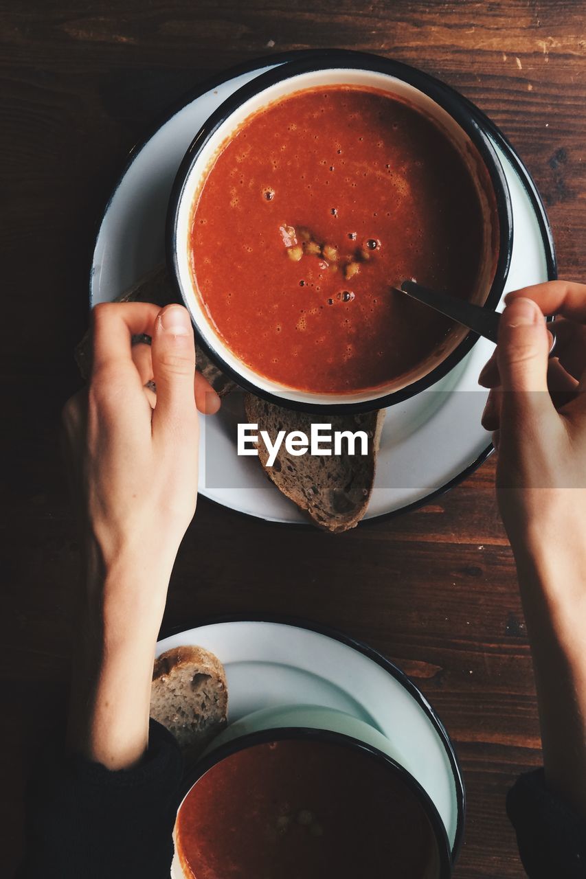 Cropped hands on woman with fresh soup on table