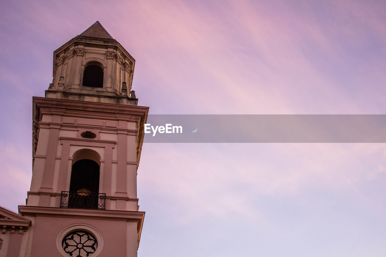 Low angle view of bell tower against sky during sunset