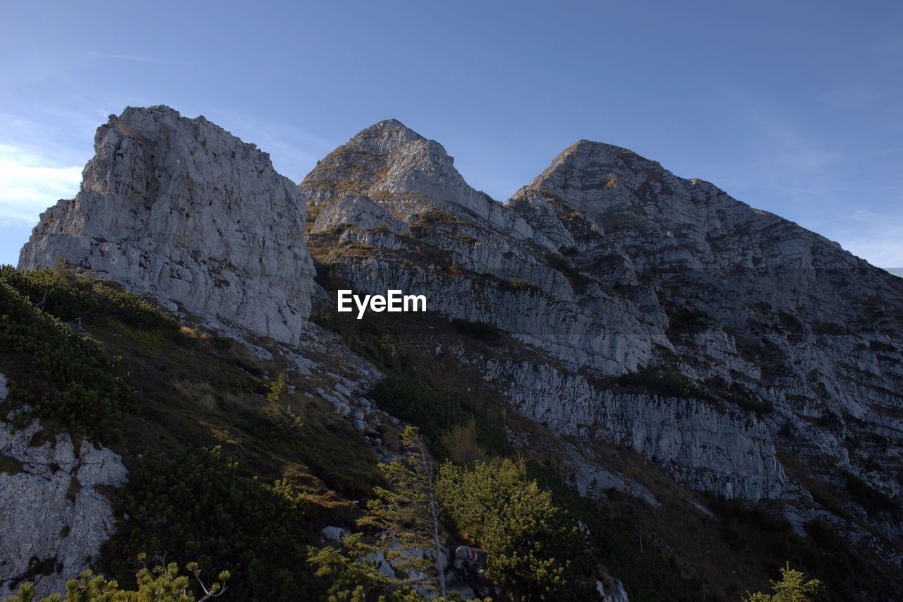 Low angle view of rocky mountains against sky