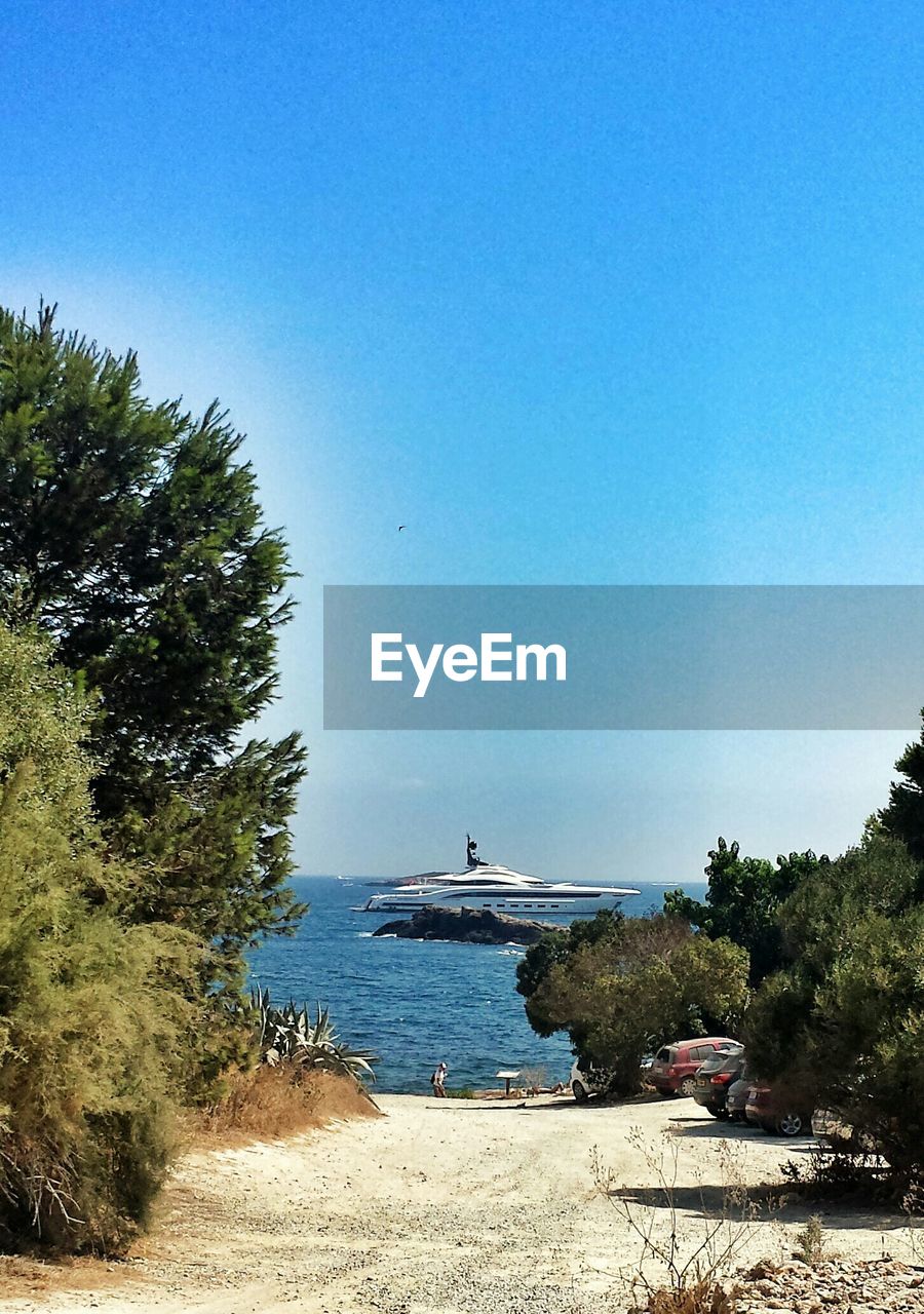 Yacht sailing on sea against clear blue sky