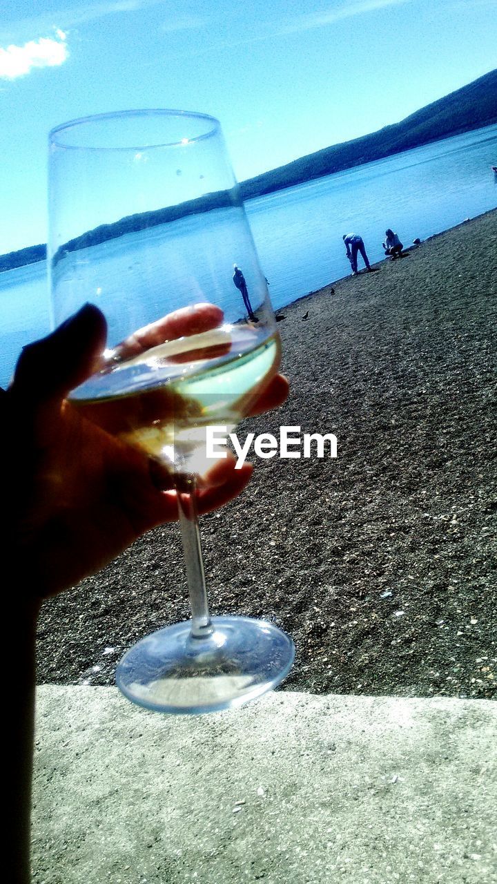 CLOSE-UP OF HAND HOLDING BEER GLASS