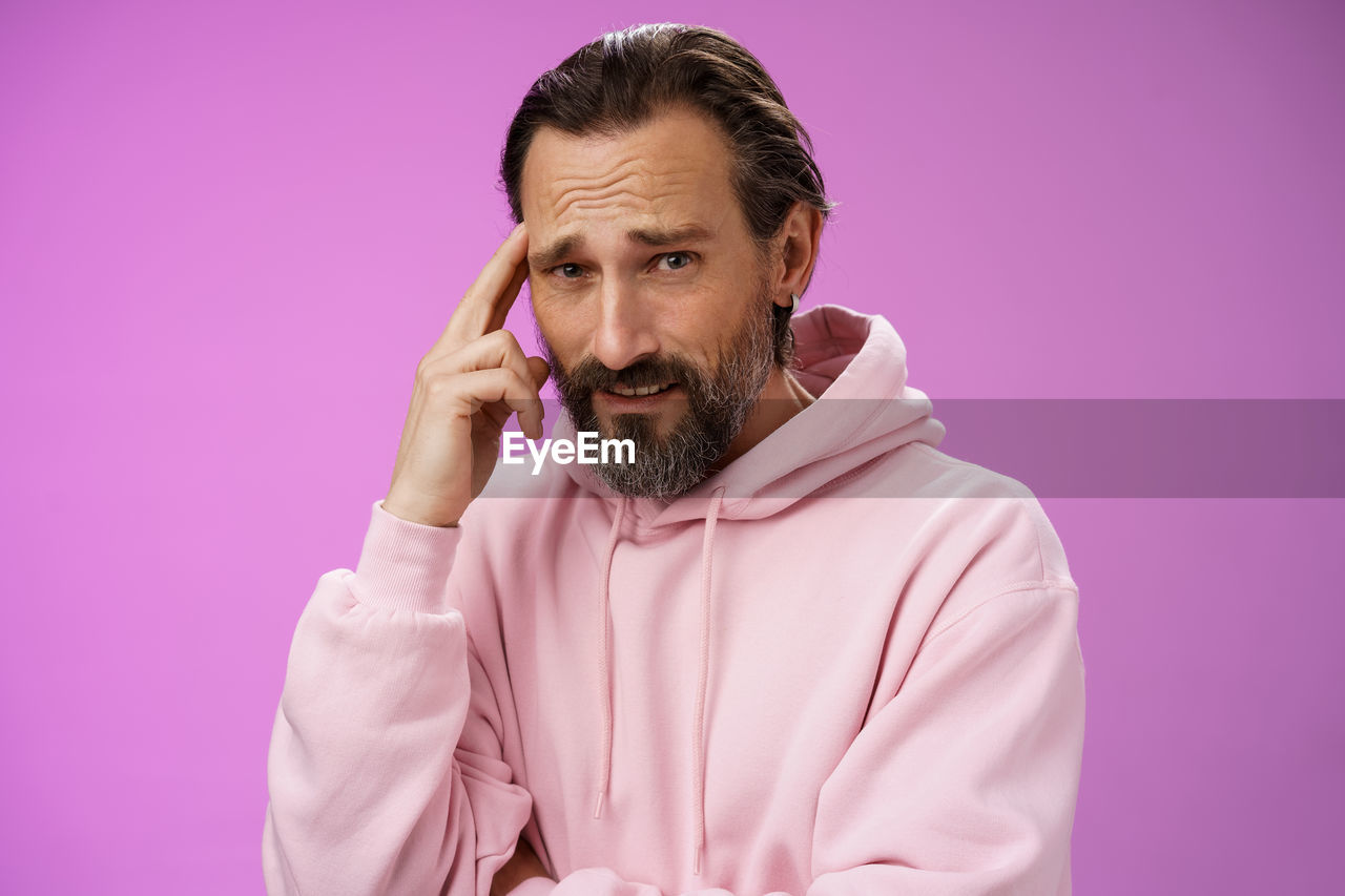 Thoughtful man against purple background