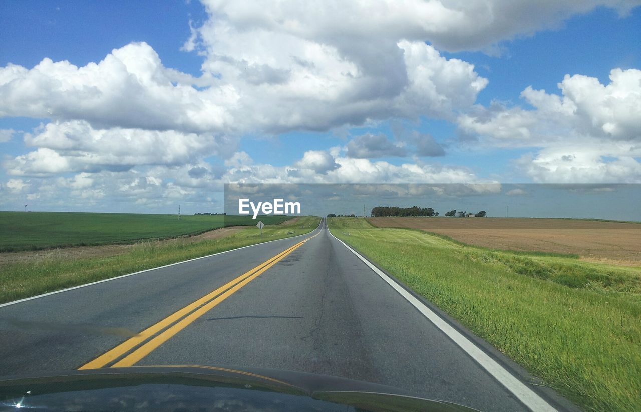 VIEW OF ROAD AMIDST FIELD AGAINST SKY