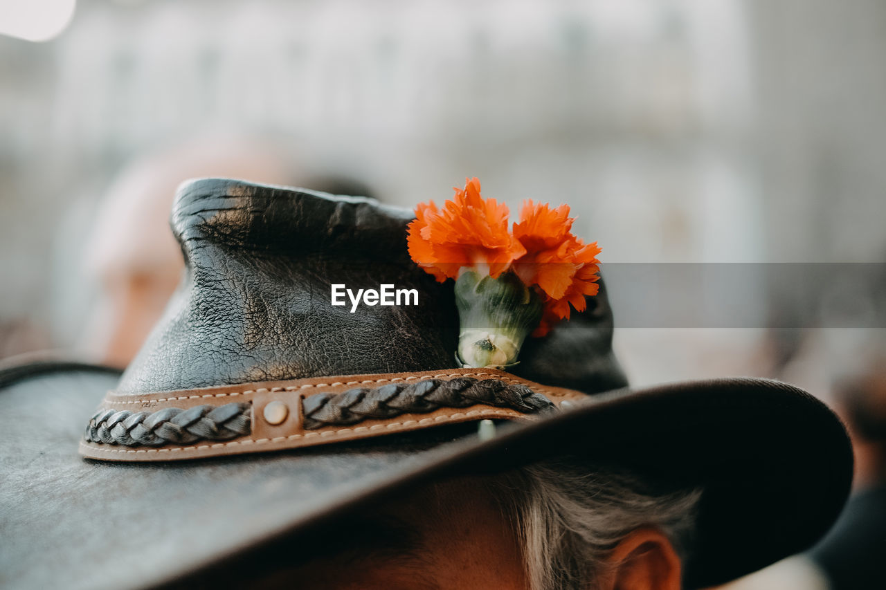 Close-up of person wearing hat and flower