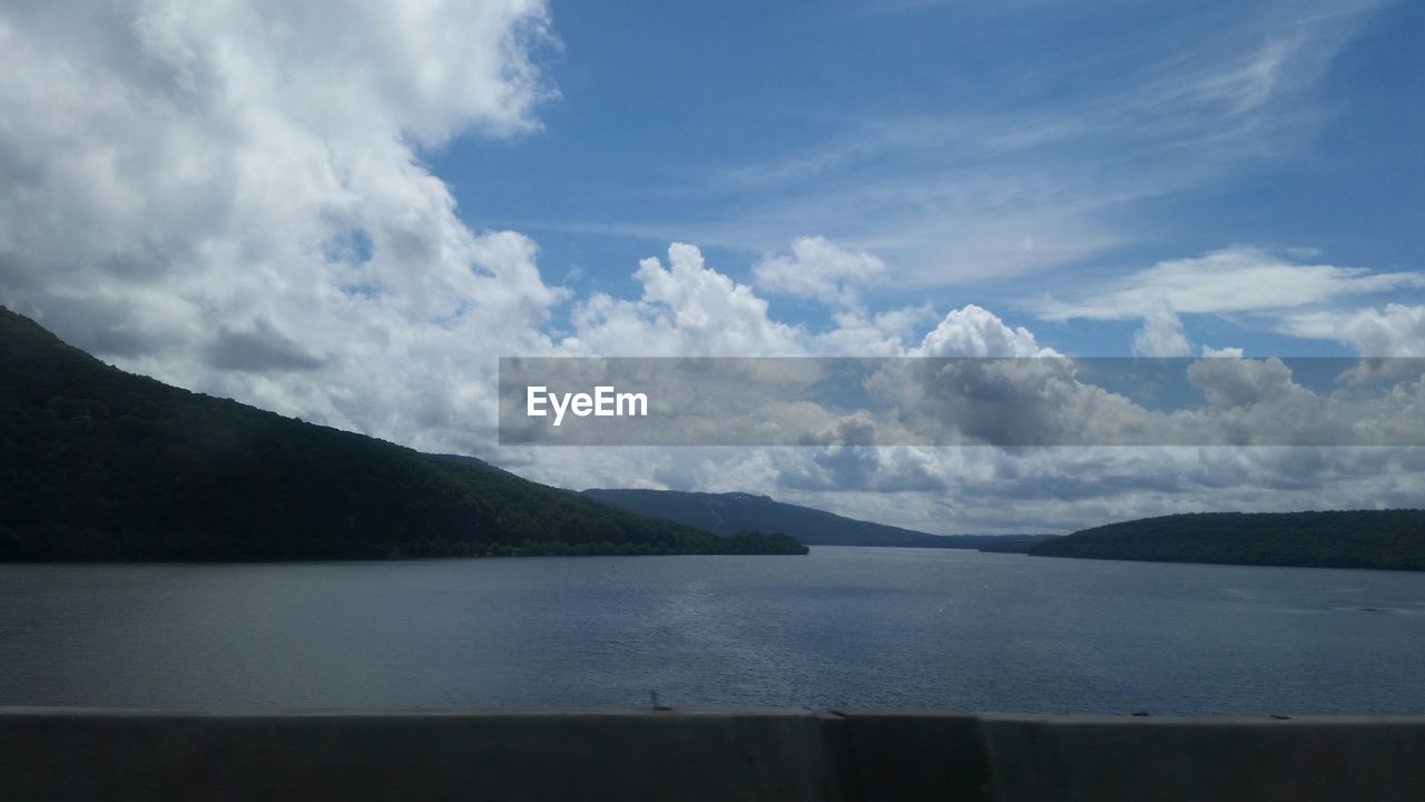 SCENIC VIEW OF LAKE BY MOUNTAIN AGAINST SKY