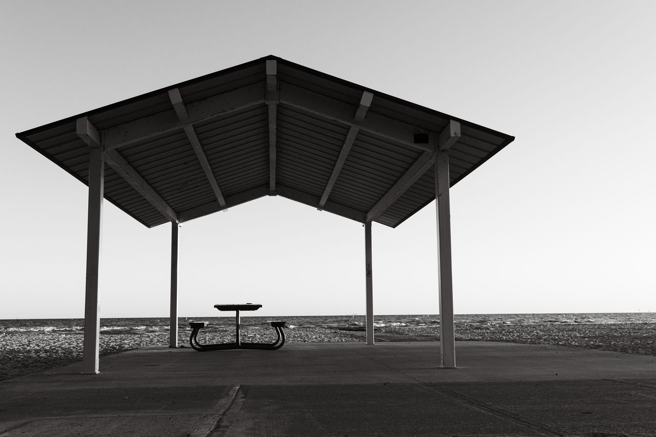 sky, black and white, beach, sea, water, architecture, nature, horizon, horizon over water, land, built structure, monochrome, monochrome photography, clear sky, day, no people, white, outdoors, tranquility, black, hut, scenics - nature, transportation