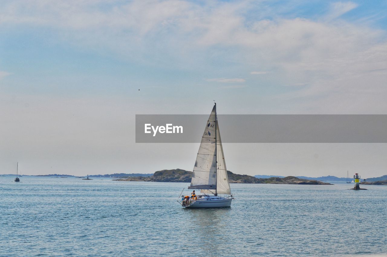 SAILBOATS SAILING IN SEA AGAINST SKY