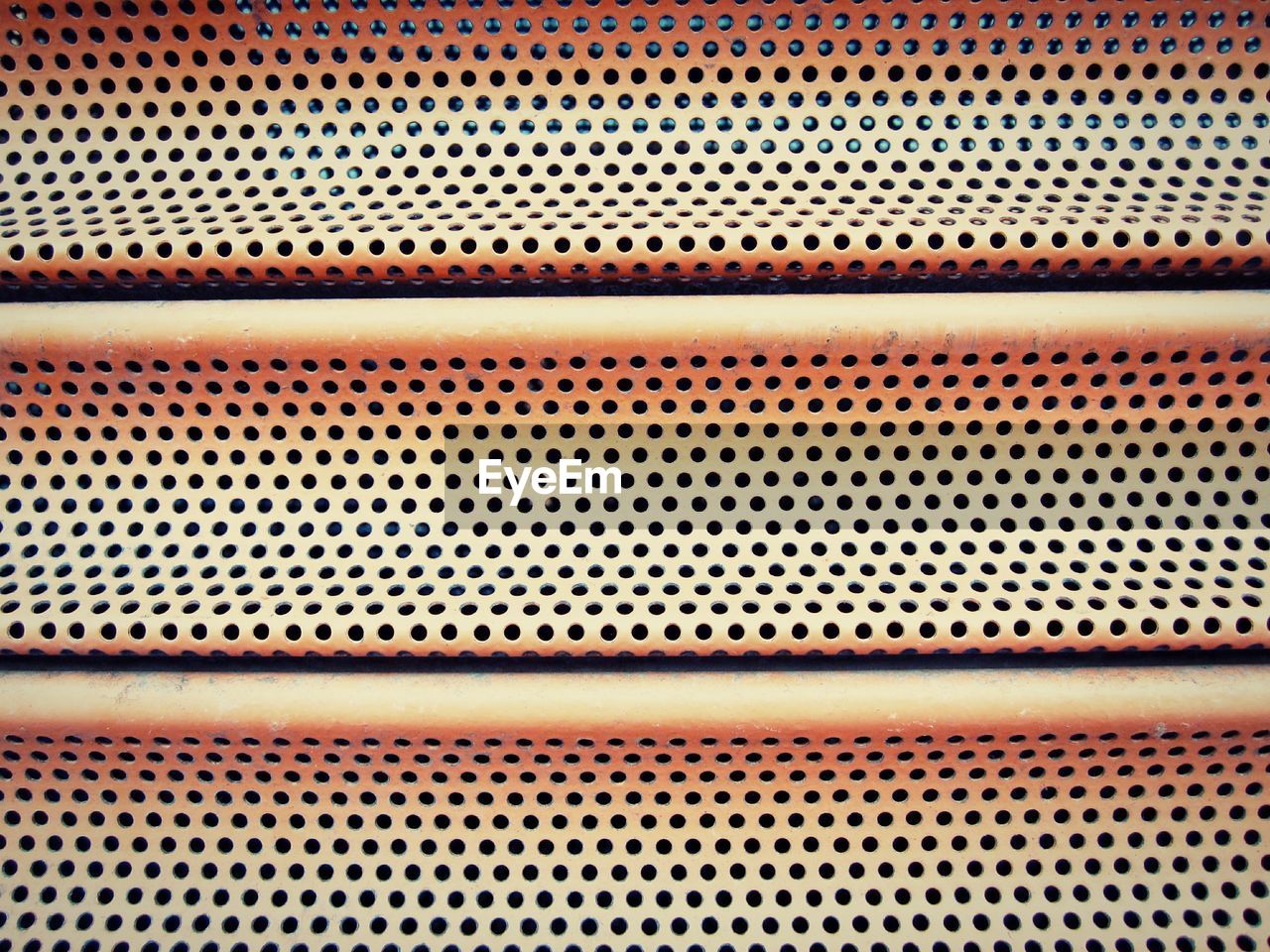 Full frame shot of holes on metal