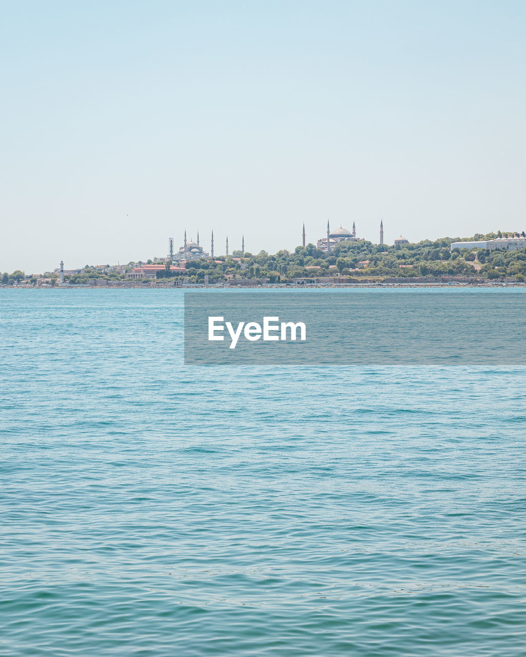 SCENIC VIEW OF SEA AGAINST BUILDINGS IN CITY