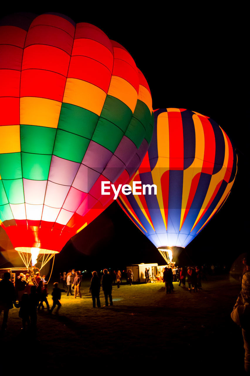 People by hot air balloons at night
