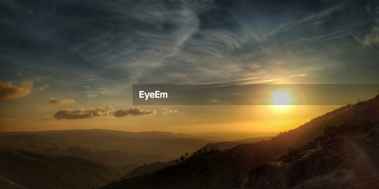 SCENIC VIEW OF MOUNTAINS AGAINST DRAMATIC SKY