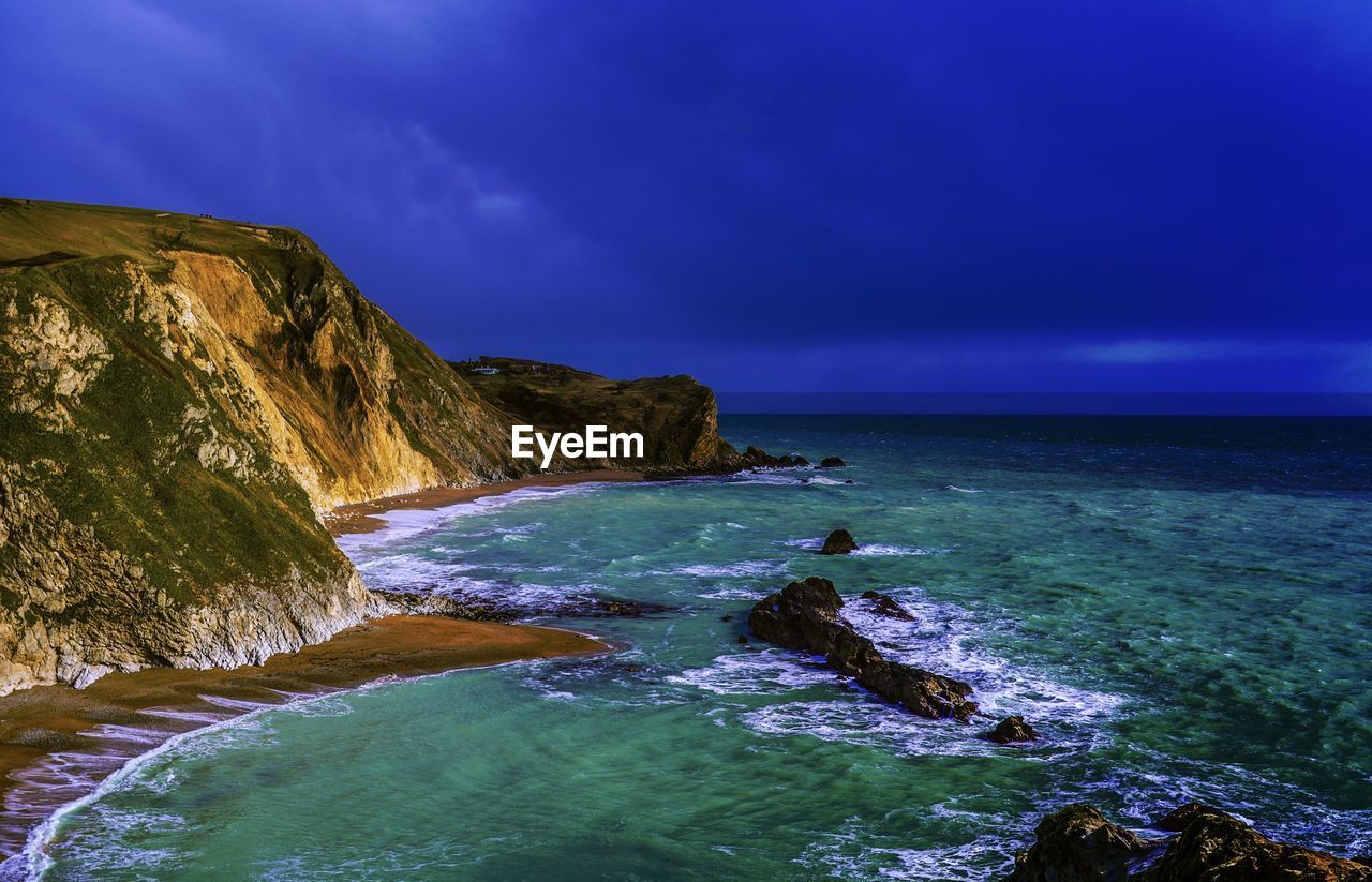 SCENIC VIEW OF BEACH AGAINST BLUE SKY