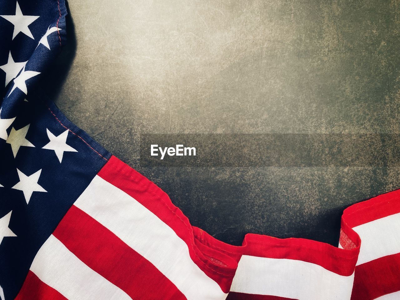 CLOSE-UP HIGH ANGLE VIEW OF FLAG AGAINST THE WALL