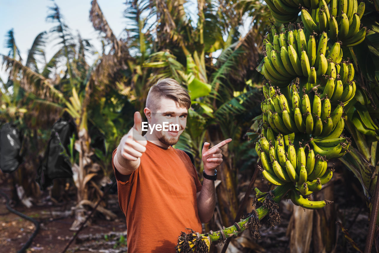 FULL LENGTH OF MAN STANDING BY TREE