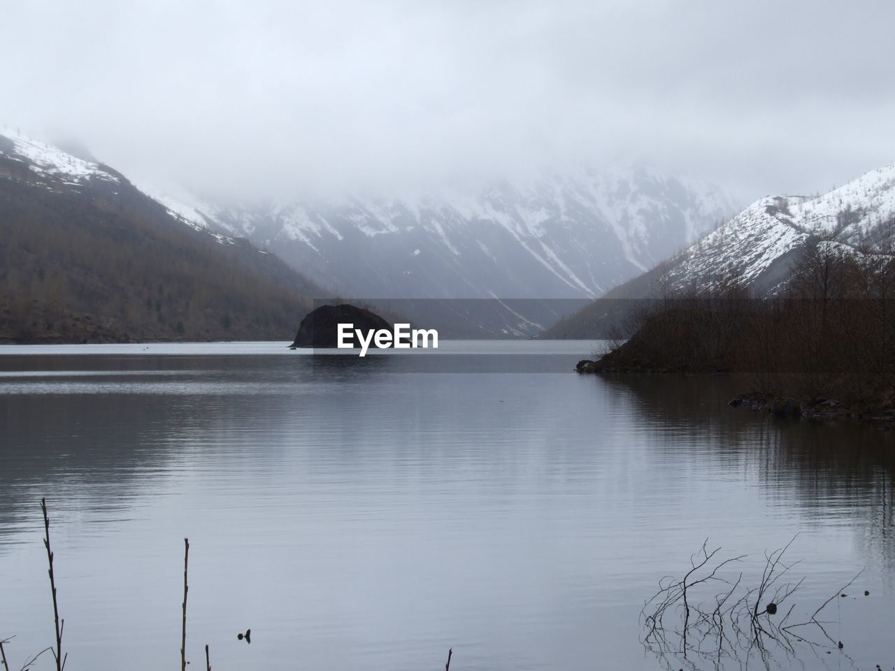 water, mountain, scenics - nature, snow, cold temperature, winter, lake, beauty in nature, environment, landscape, reflection, mountain range, nature, sky, reservoir, tranquility, tranquil scene, fog, tree, snowcapped mountain, no people, cloud, travel destinations, glacial landform, forest, plant, land, non-urban scene, ice, travel, wilderness, tourism, outdoors, overcast, highland, day, mountain peak, idyllic, pine woodland
