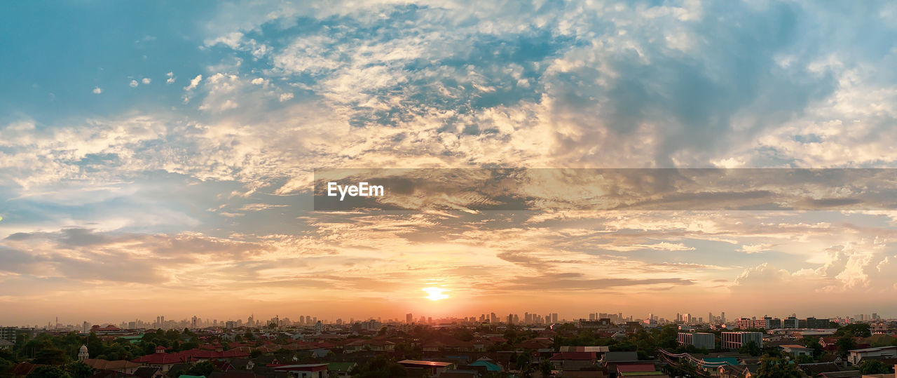 Silhouette of the bangkok city with an afternoon sunset and epic sky clouds. wide aspect ratio.