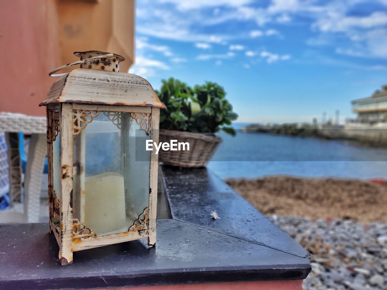 CLOSE-UP OF OLD WOODEN TABLE AGAINST SEA