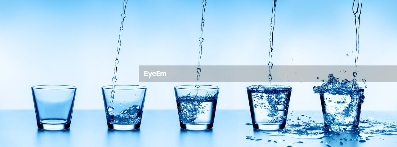 Close-up of glasses on table against blue background