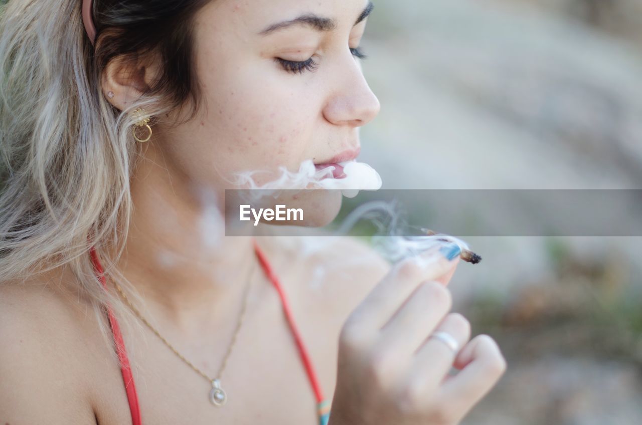 Close-up of woman smoking marijuana joint