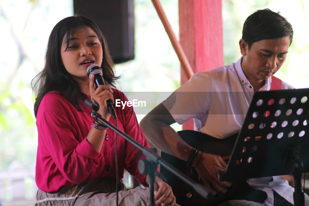 Side view of young woman singing