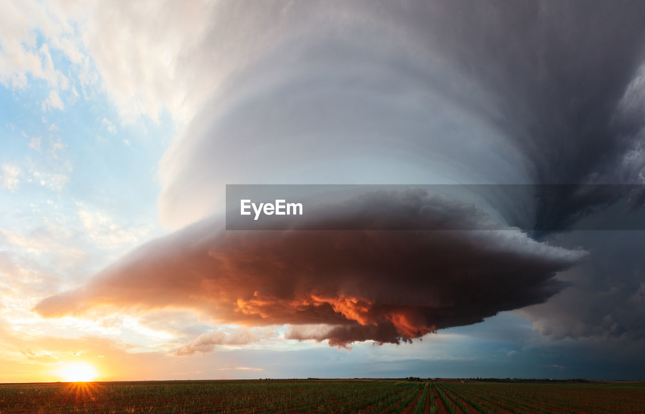 A dramatic supercell storm at sunset over a field near earth, texas