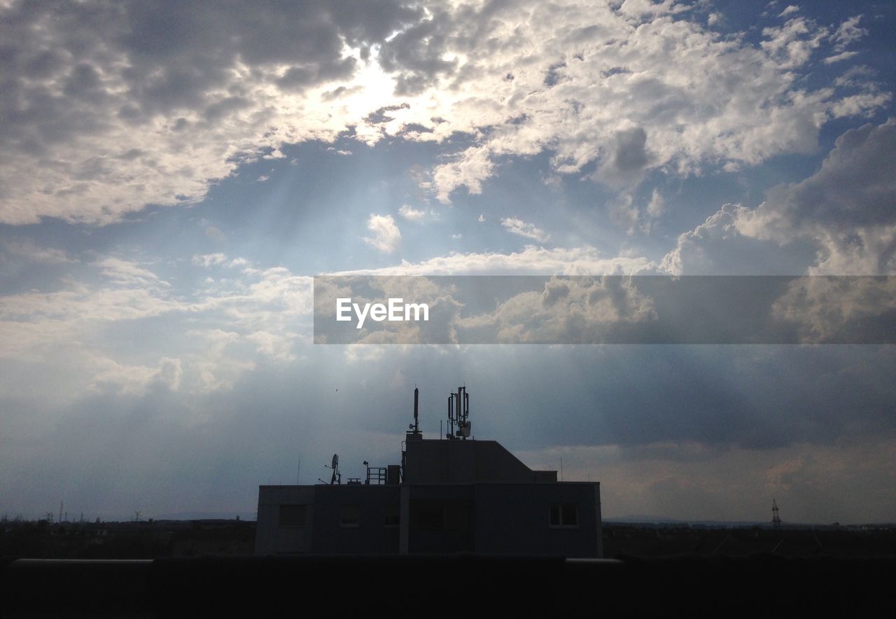 Silhouette building against cloudy sky